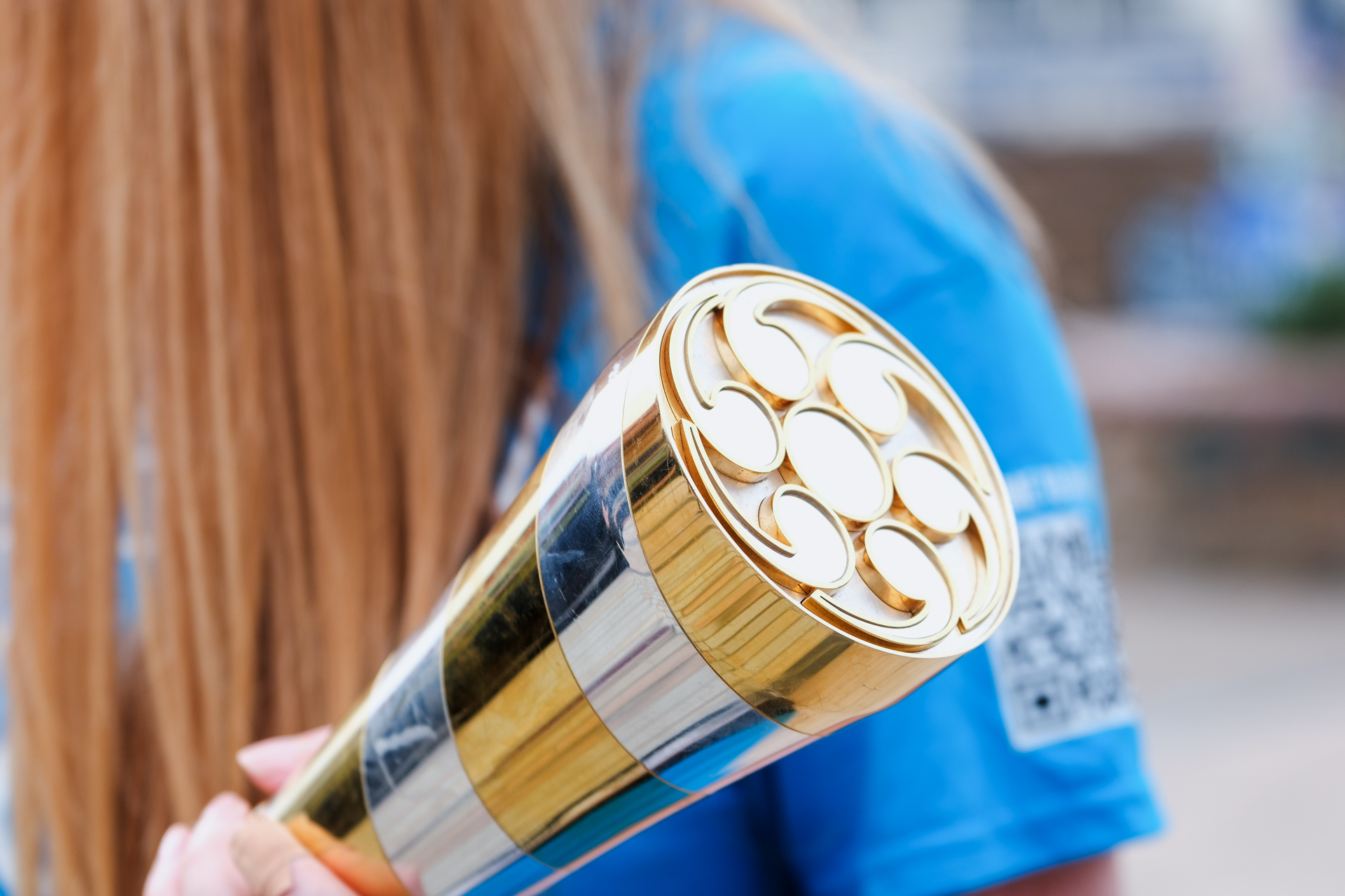 A close-up photo of a woman holding a decorative metal baton.