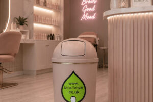 A pink waste paper bin inside a beauty salon.