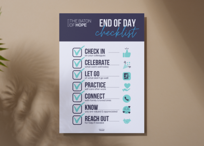 A mockup design of a printed poster on a neutral coloured wall next to a house plant.